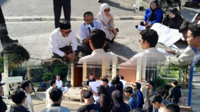 MENUNTUT. Potret mahasiswa STKIP PGRI Sumenep menggelar aksi di depan kampus, menuntut pemecatan dosen yang diduga terlibat skandal, Selasa (25/3/2025). (Dok. Redaksi Parekas)